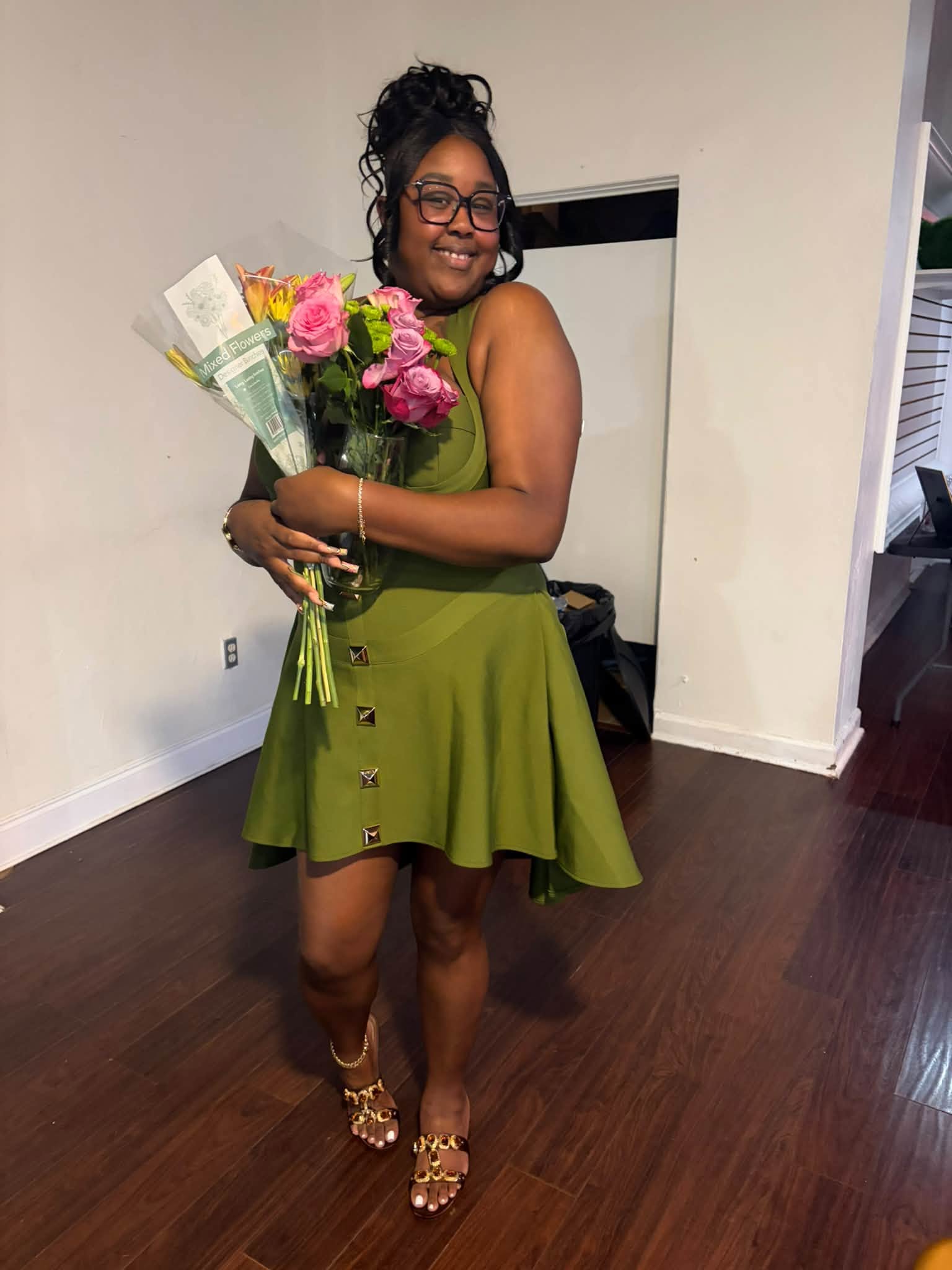 Chardonnay Ashanti in a green dress holding a bouquet of flowers