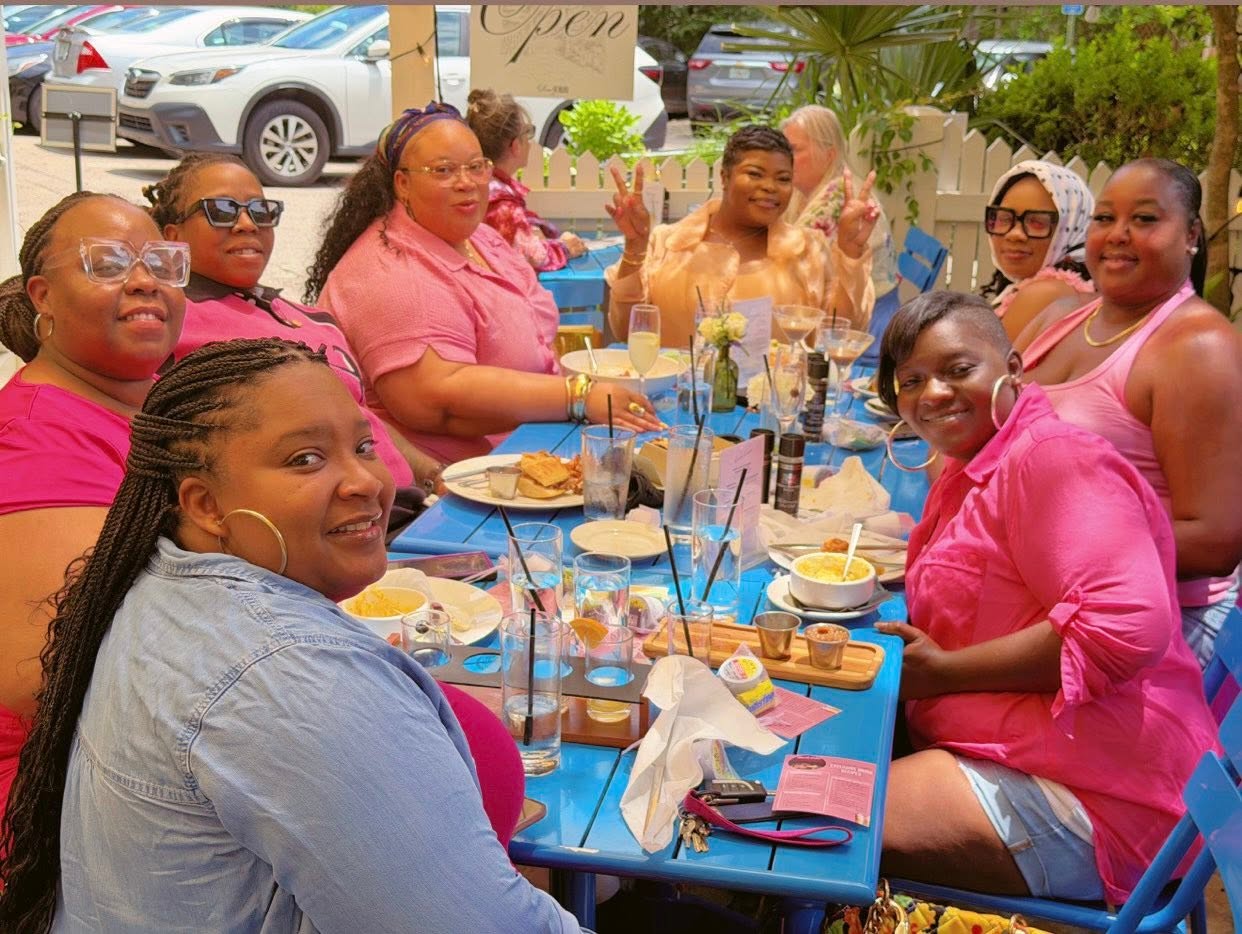 Members seated around a blue table at brunch